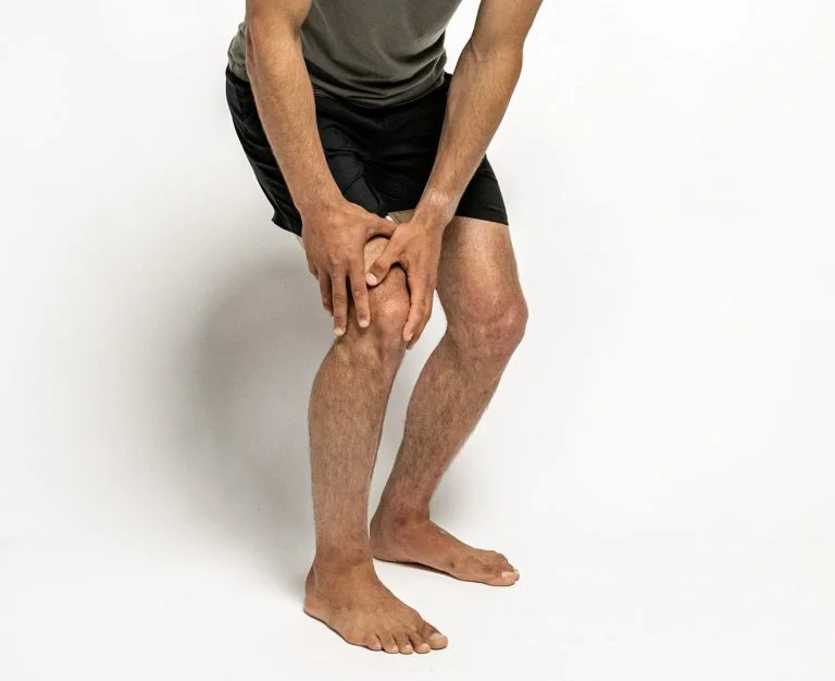 Person holding a painful knee.